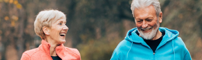 Una mujer y un hombre de más de 60 años sonríen mientras dan un paseo